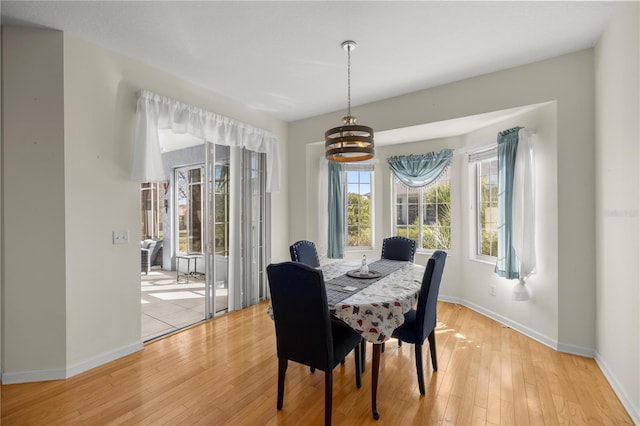 dining space with light wood-style flooring and baseboards