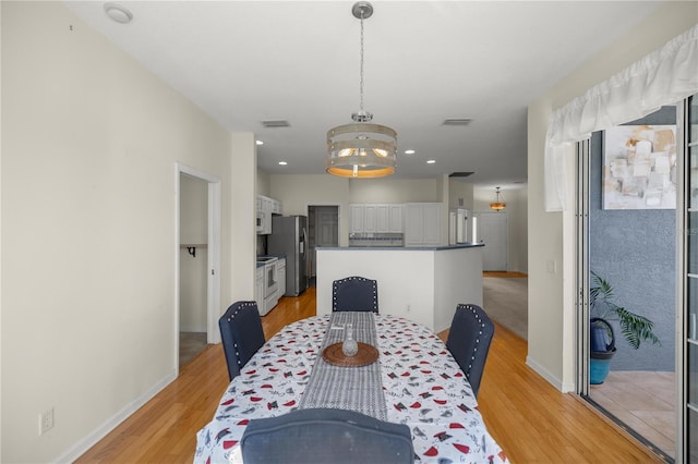 dining space featuring light wood-style flooring, recessed lighting, and baseboards