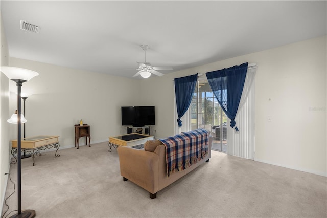 living room featuring ceiling fan, baseboards, visible vents, and light carpet