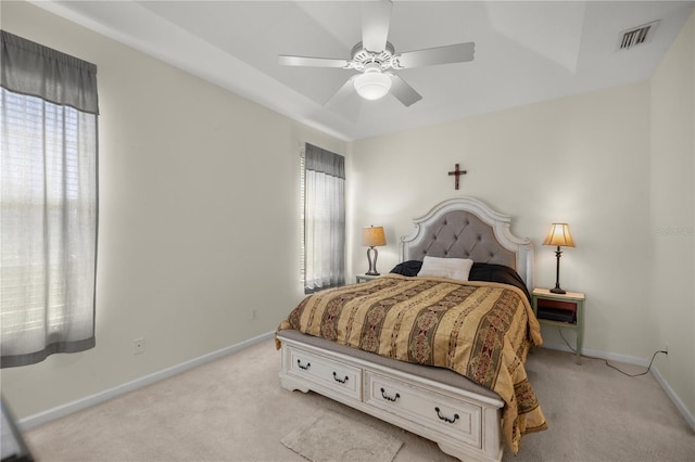 bedroom featuring baseboards, multiple windows, and light carpet