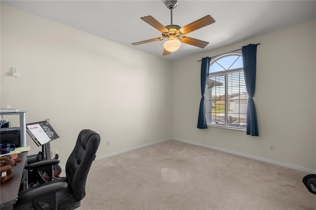 carpeted home office with baseboards and ceiling fan