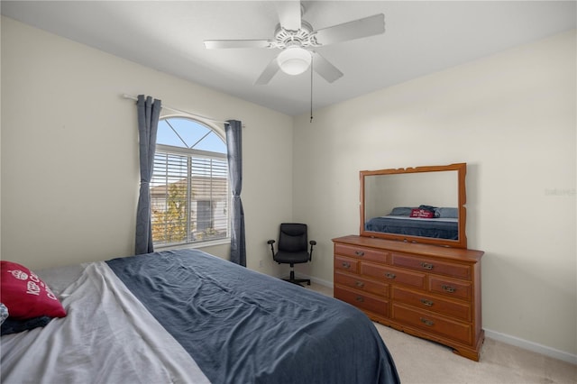 bedroom featuring light colored carpet, a ceiling fan, and baseboards