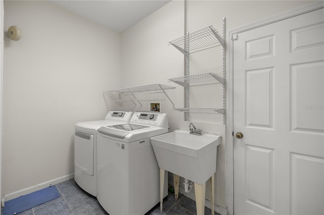 clothes washing area featuring laundry area, baseboards, tile patterned floors, and washing machine and clothes dryer