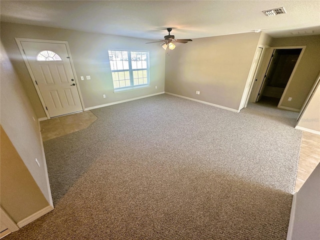 foyer featuring ceiling fan, carpet, visible vents, and baseboards