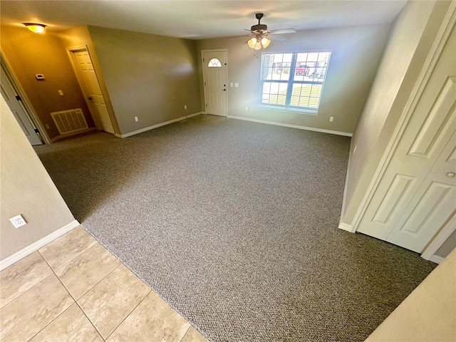 interior space featuring visible vents, baseboards, carpet, and ceiling fan