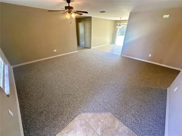 spare room featuring visible vents, baseboards, light colored carpet, and ceiling fan with notable chandelier