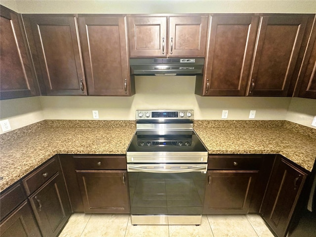 kitchen featuring light tile patterned floors, electric stove, under cabinet range hood, and dark brown cabinets