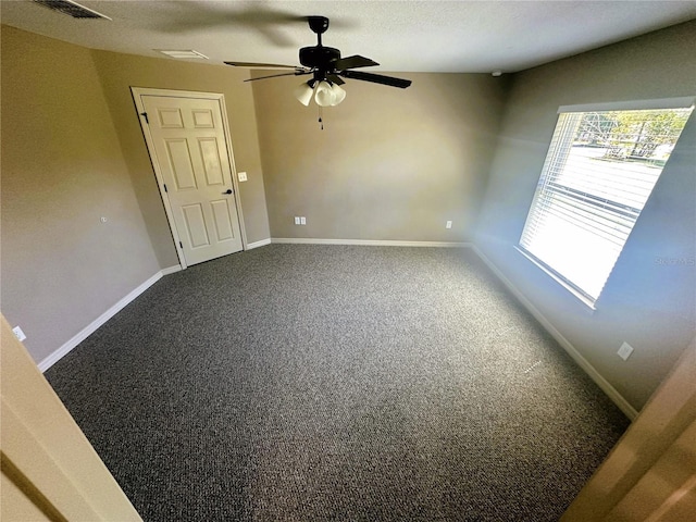 carpeted spare room with visible vents, a textured ceiling, baseboards, and a ceiling fan