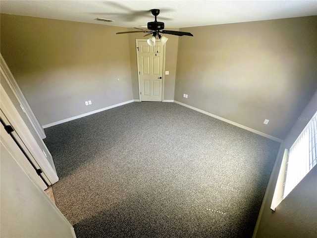 unfurnished bedroom featuring dark colored carpet, visible vents, baseboards, and ceiling fan