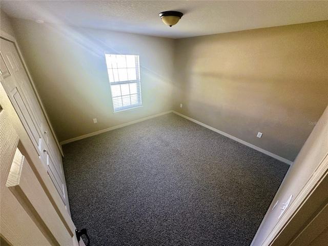 unfurnished bedroom with a textured ceiling, baseboards, and carpet floors