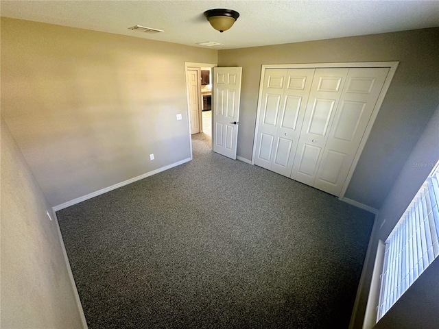 unfurnished bedroom featuring visible vents, carpet floors, baseboards, and a closet