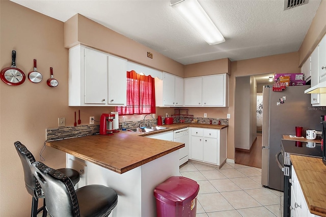 kitchen featuring electric range, visible vents, a sink, a peninsula, and white dishwasher