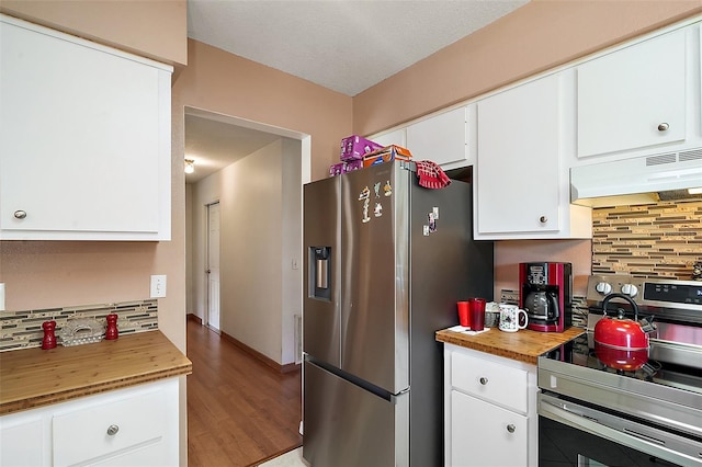 kitchen featuring backsplash, under cabinet range hood, butcher block countertops, white cabinets, and stainless steel appliances