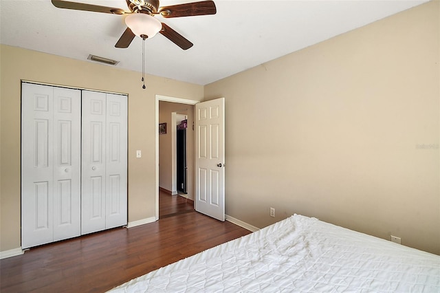 bedroom featuring visible vents, baseboards, a closet, and wood finished floors