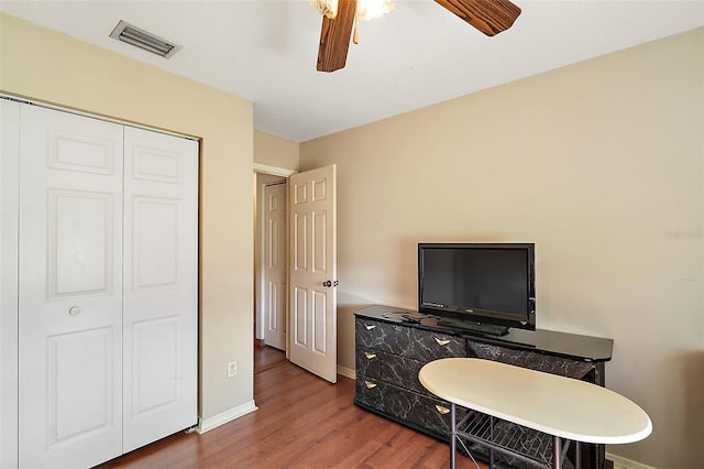 office with ceiling fan, wood finished floors, visible vents, and baseboards