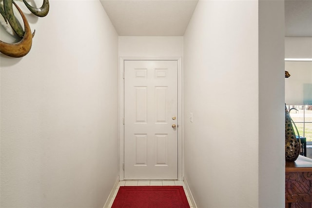 corridor with tile patterned floors and baseboards