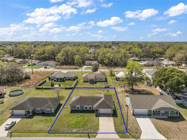 birds eye view of property featuring a wooded view and a residential view