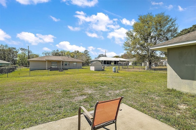 view of yard with a fenced backyard, a storage unit, and an outdoor structure