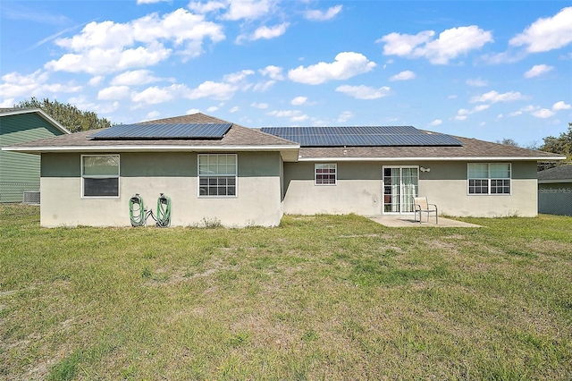 rear view of house featuring a patio area, roof mounted solar panels, stucco siding, and a yard