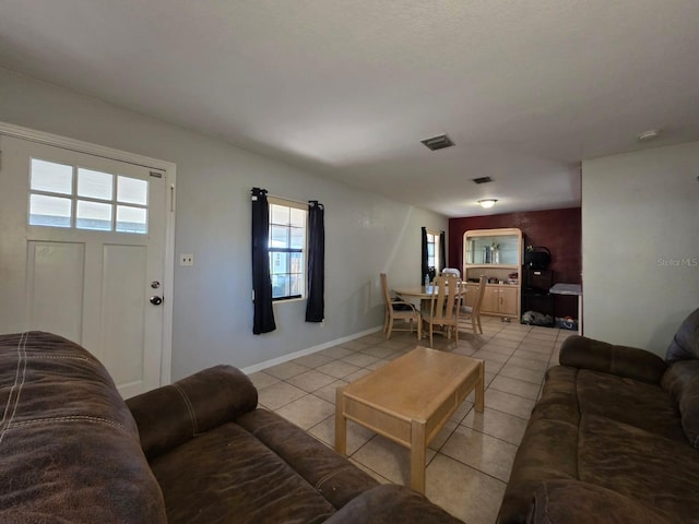 living area with light tile patterned floors, baseboards, and visible vents