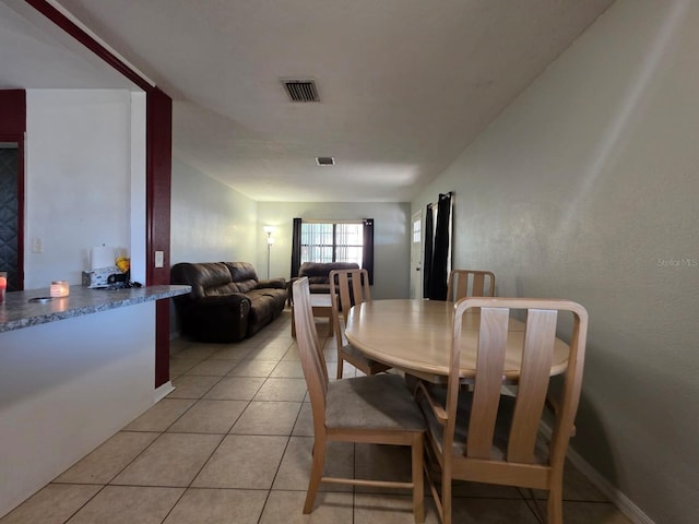 dining space featuring light tile patterned floors, baseboards, and visible vents