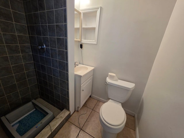 bathroom with vanity, baseboards, a stall shower, tile patterned floors, and toilet