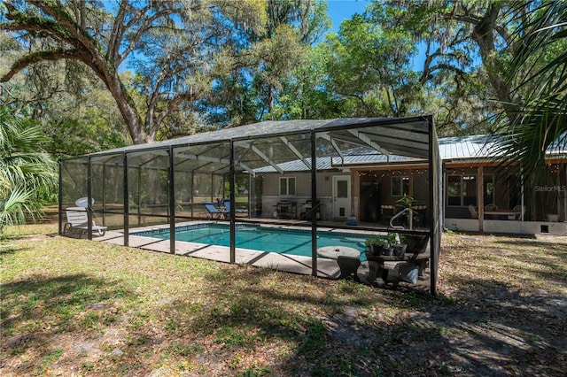outdoor pool with a patio, a lawn, and a lanai