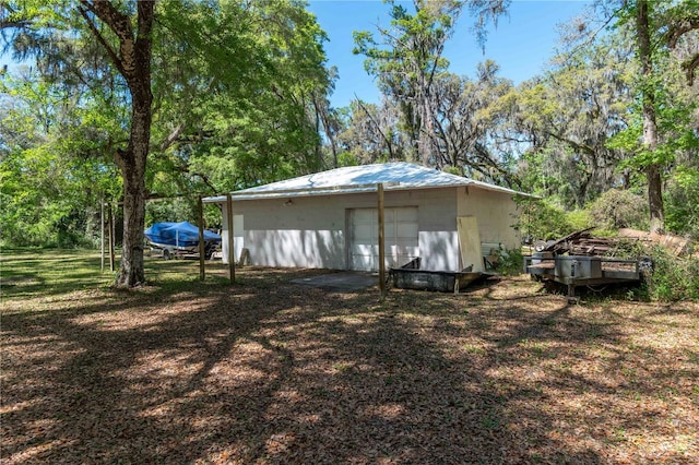 view of yard with a detached garage and an outbuilding