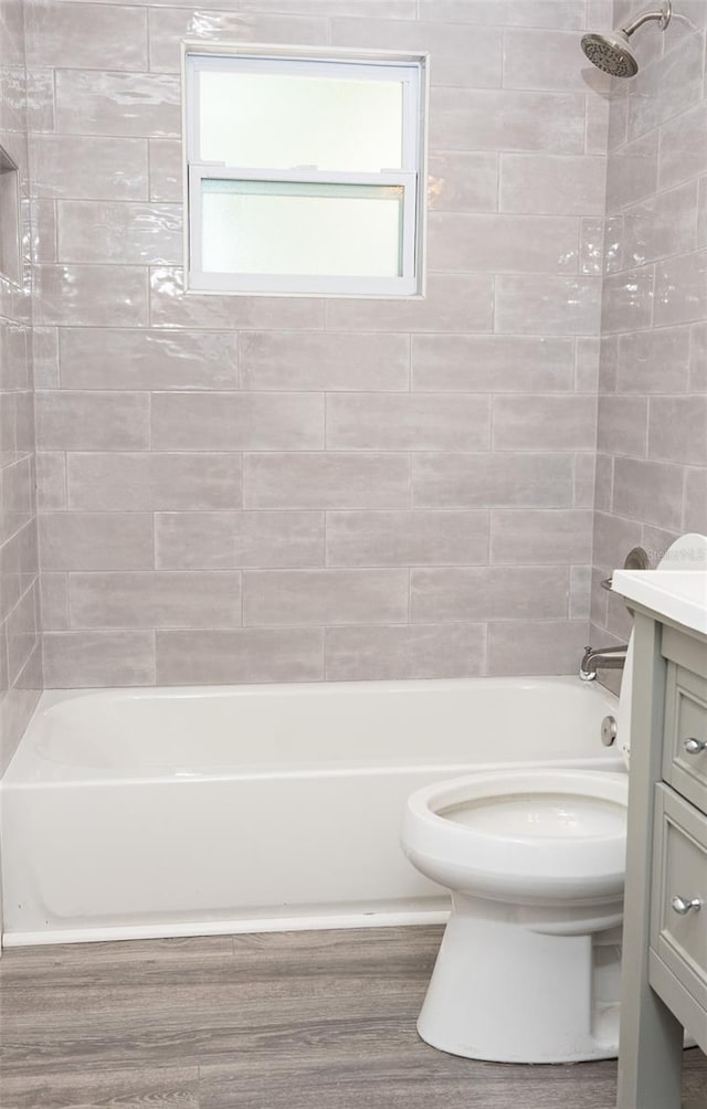 bathroom featuring vanity, toilet, shower / tub combination, and wood finished floors