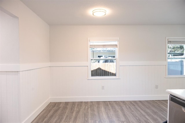 empty room with a wainscoted wall and wood finished floors