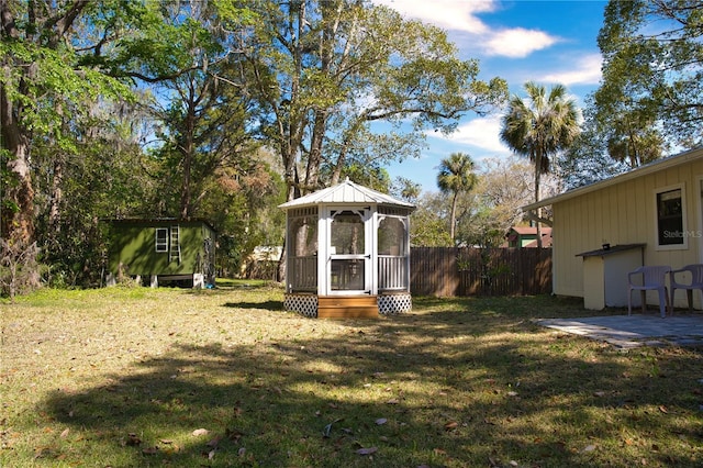 view of yard featuring an outdoor structure and fence