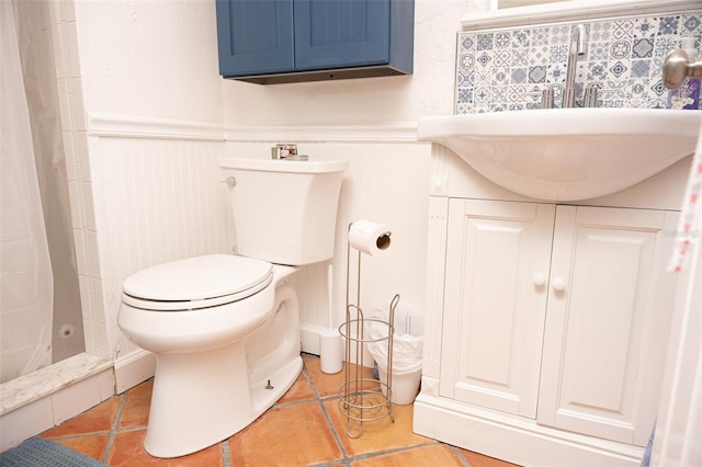 full bathroom with a wainscoted wall, curtained shower, toilet, and vanity