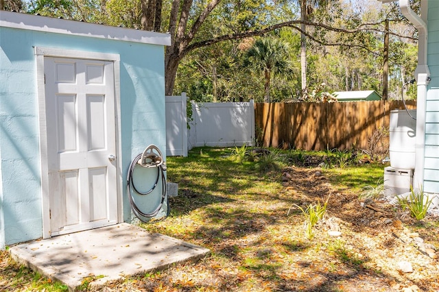 view of yard featuring an outbuilding, a storage shed, and fence