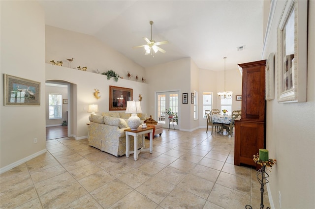 living area with plenty of natural light, ceiling fan with notable chandelier, visible vents, and arched walkways