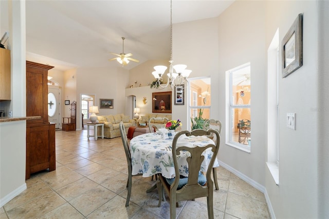 dining area with baseboards, high vaulted ceiling, light tile patterned flooring, and ceiling fan with notable chandelier