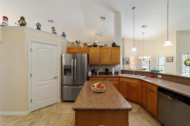 kitchen featuring brown cabinetry, visible vents, an inviting chandelier, a sink, and stainless steel appliances