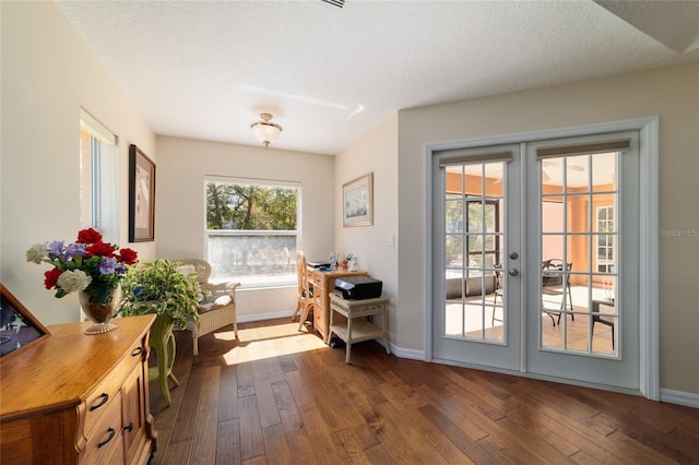 doorway with french doors, a textured ceiling, baseboards, and dark wood-style flooring