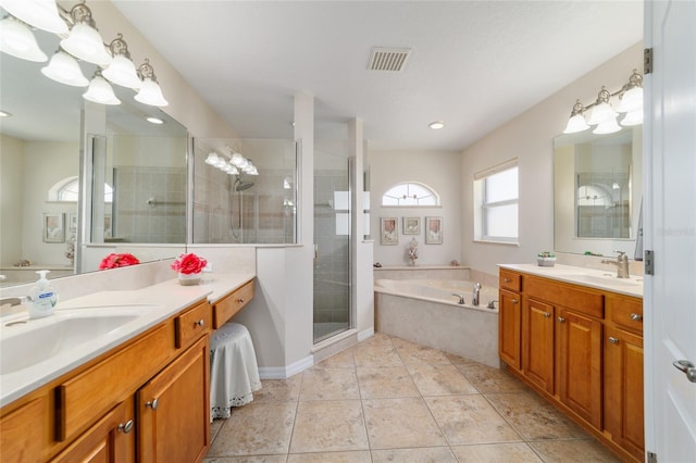 full bathroom featuring visible vents, a sink, a shower stall, a garden tub, and tile patterned floors