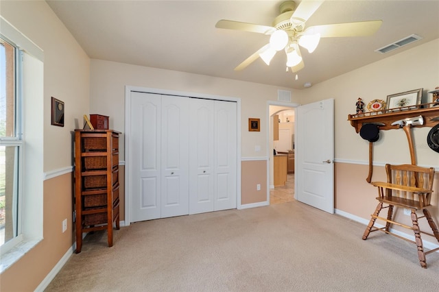 bedroom featuring light carpet, visible vents, arched walkways, and a closet