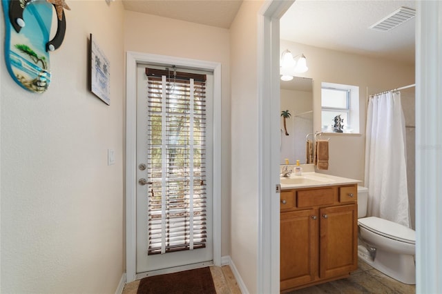 bathroom featuring a wealth of natural light, visible vents, toilet, and vanity