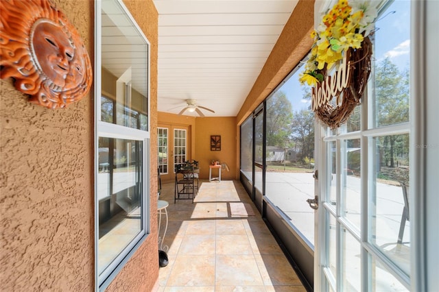 sunroom / solarium with french doors and a ceiling fan