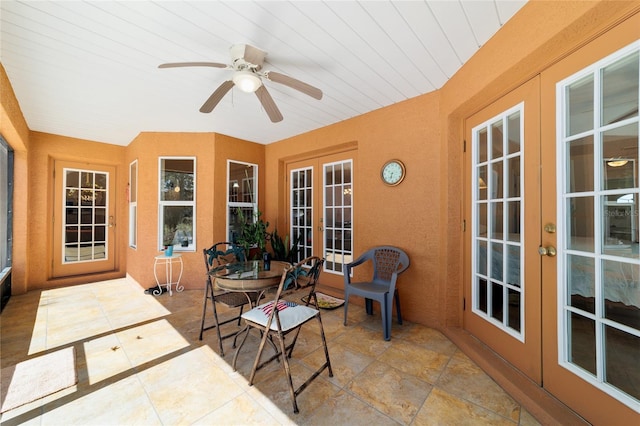 sunroom / solarium featuring french doors and a ceiling fan