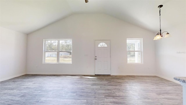 foyer entrance with vaulted ceiling, a notable chandelier, wood finished floors, and baseboards