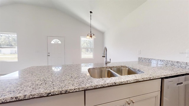 kitchen with light stone countertops, a sink, vaulted ceiling, pendant lighting, and dishwasher