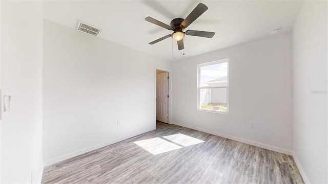 unfurnished room with ceiling fan, visible vents, baseboards, and light wood-style flooring