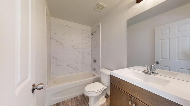 bathroom featuring visible vents, tub / shower combination, toilet, wood finished floors, and vanity