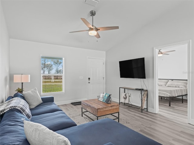 living area with visible vents, baseboards, wood finished floors, and vaulted ceiling