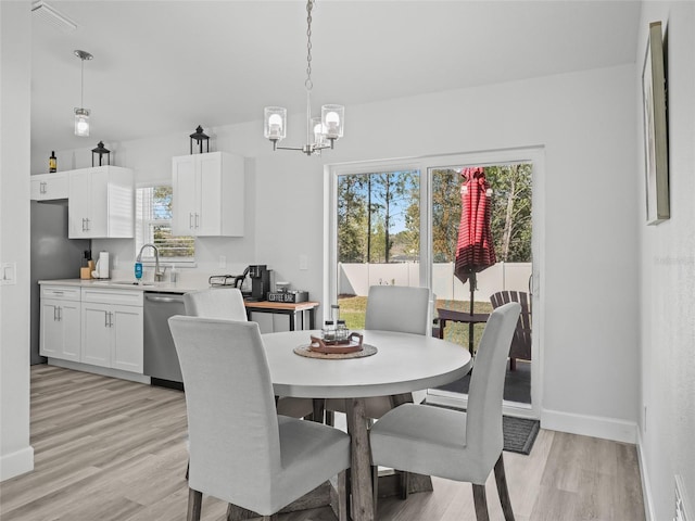 dining area featuring visible vents, a notable chandelier, baseboards, and light wood-type flooring