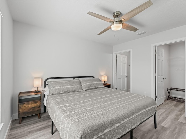 bedroom with visible vents, baseboards, light wood-type flooring, and a ceiling fan