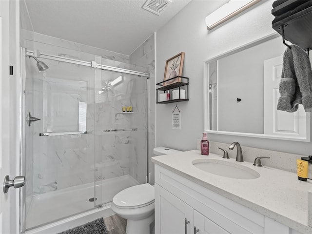 full bath featuring vanity, toilet, visible vents, and a marble finish shower